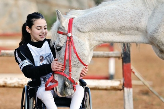 ركوب الخيل يساعد طفلة فلسطينية مصابة بشلل نصفي
