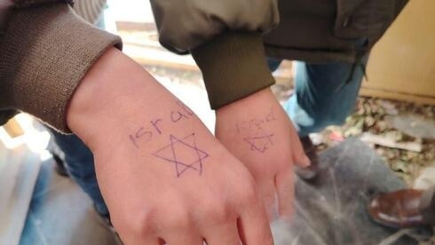 حدث في الخليل.. جنود الاحتلال يرسمون "نجمة داوود "على أيدي الأطفال