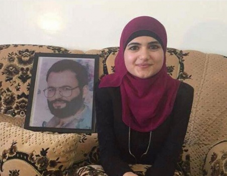 عوض الله "الجنين" تحتفل بتفوقها مع صورة والدها الشهيد