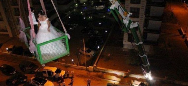 فيديو: عروسان يصعدان لمنزل الزوجية بـ"الونش"!.. والسبب؟
