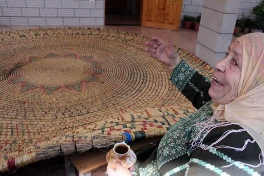 بالصور..حاجة من رام الله تنتهي من صناعة أكبر صينية قش في العالم