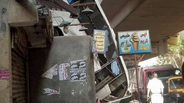 صور صادمة.. حافلة تسقط وتتعلق بركابها فوق منزل بمصر