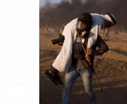 صورة - الصحفي حاتم عمر يسعف مسنا على الحدود