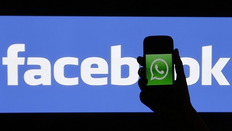 A woman holds a smartphone displaying WhatsApp's logo in front of the screen with the Facebook logo in this photo illustration taken in Prague February 20, 2014. Facebook Inc's purchase of fast-growing mobile-messaging start-up WhatsApp for $19 billion (11 billion pounds) stunned the markets but analysts said the deal made strategic sense as it will solidify the social network's position as a leader in mobile.     REUTERS/David W Cerny (CZECH REPUBLIC - Tags: BUSINESS LOGO SCIENCE TECHNOLOGY TELECOMS) - RTX197O8