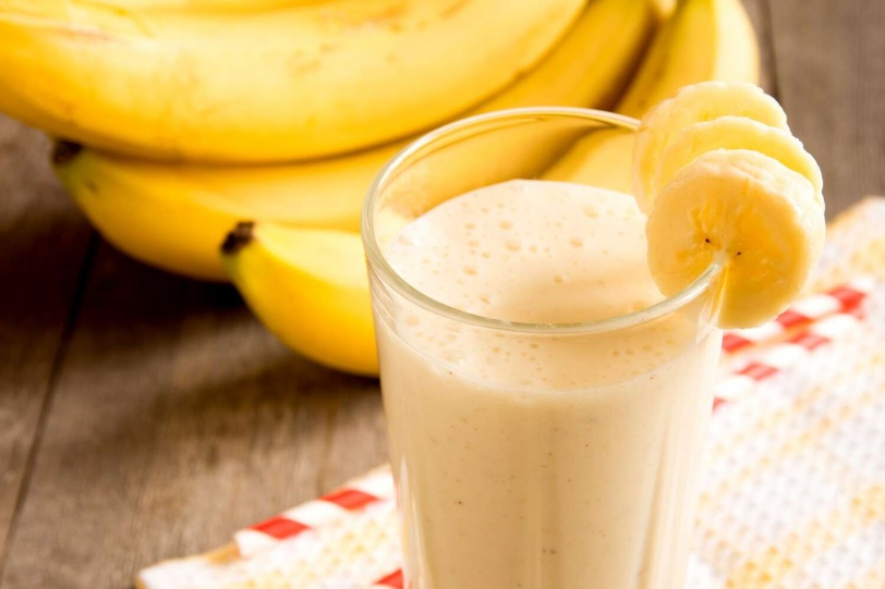 Banana smoothie on wooden background